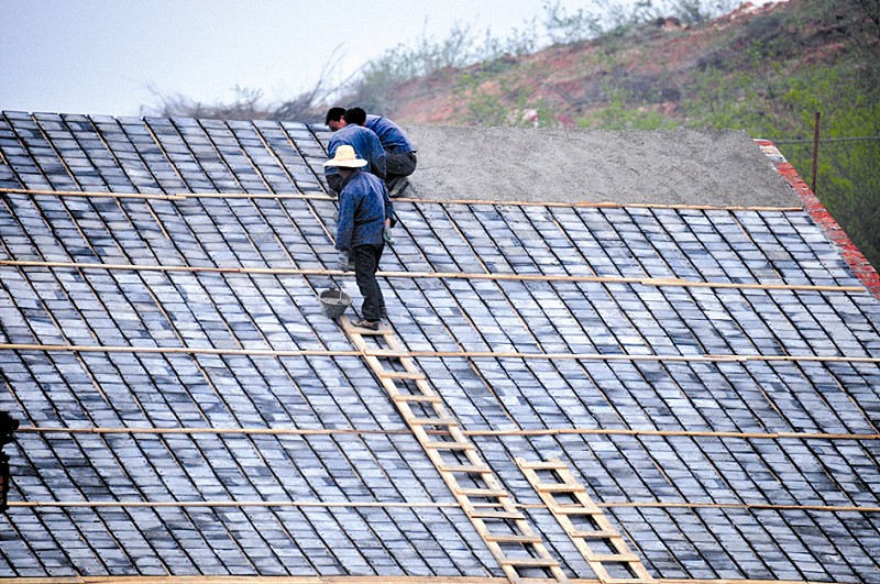 工人在复建的大成殿屋顶铺瓦